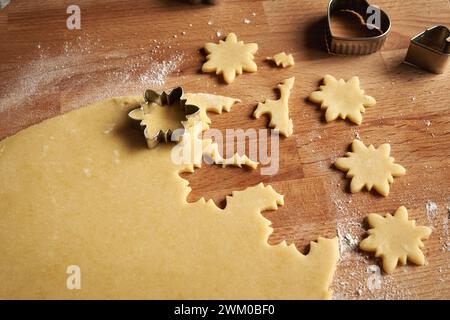 Cutting out star shapes from rolled out dough to prepare Linzer Christmas cookies Stock Photo