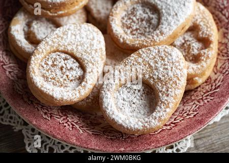 Linzer cookies in the shape of Easter eggs on a red plate Stock Photo