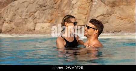 happy couple cuddling in swimming pool. romantic getaway. banner with copy space Stock Photo