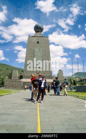 The Mitad del Mundo (Middle of the World) Monument (Monument to the Equator) in Quito, capital city of Ecuador, South America. Tourists pose standing astride the yellow line marking the location of the equator, but the equator actually lies about 240 metres (790 ft) north of the marked line.  Taken in 2000. Stock Photo