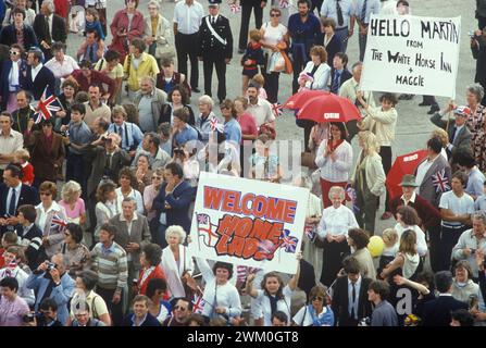 Queen Elizabeth 2 QE2 returning to Southampton Water from the Falklands War as a Troop Carriers. June 11 1982 1980s Crowds gather to welcome the British troops soldiers home. Welcome Home Lad, parents carry banner. Southampton UK HOMER SYKES Stock Photo