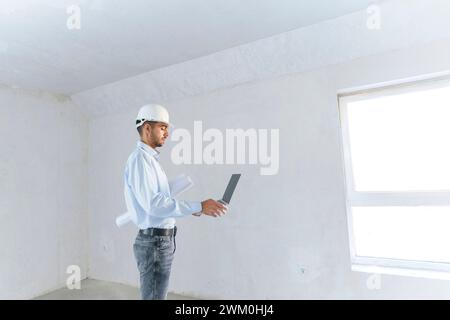 Young architect working on laptop at construction site Stock Photo