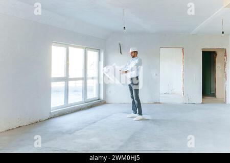 Architect examining blueprint at construction site Stock Photo