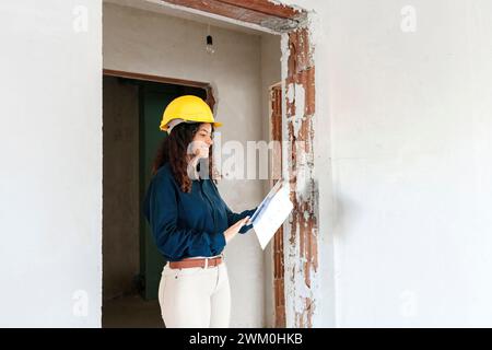 Happy young architect using tablet PC at site Stock Photo