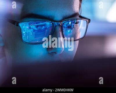 IT professional wearing eyeglasses and working on computer Stock Photo