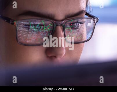 Businesswoman wearing eyeglasses analyzing financial market data on computer Stock Photo