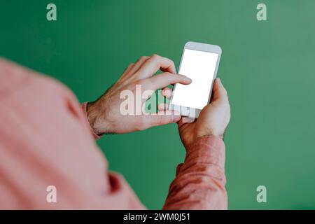 Man using smart phone near green wall Stock Photo