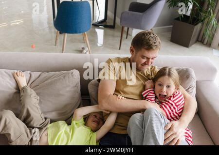 Father having fun with children at home Stock Photo