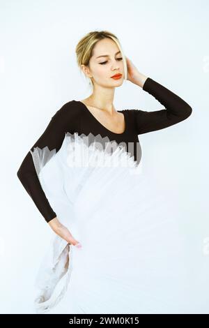 Elegant ballet dancer with white tutu standing in studio Stock Photo