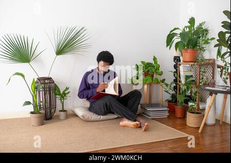 Young man reading book at home Stock Photo