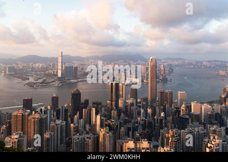 Victoria harbor near buildings in Hong Kong city at sunset Stock Photo