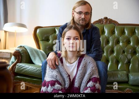 Woman with man sitting on sofa at home Stock Photo