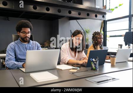 Business people working on laptops at desk Stock Photo