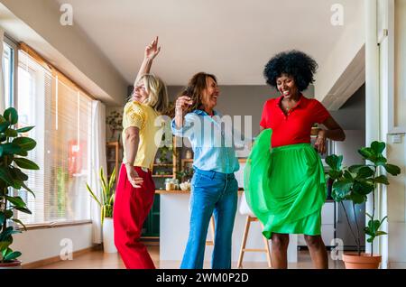 Cheerful multiracial friends dancing and having fun at home Stock Photo