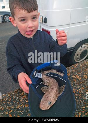 A boy holds a dogfish in Seaford, England Stock Photo