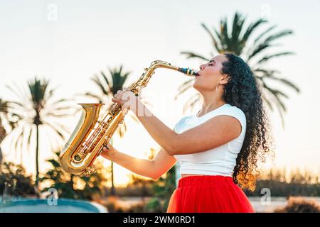Passionate woman playing saxophone at skate park Stock Photo