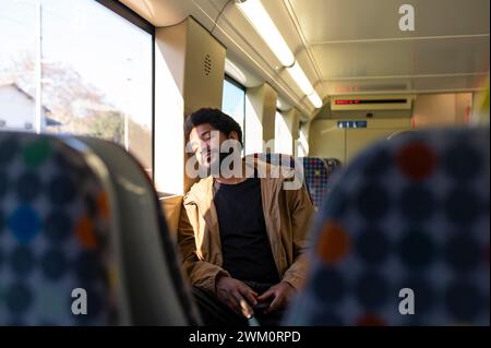 Young man napping in subway train Stock Photo