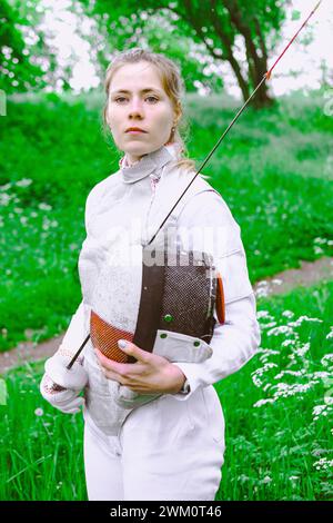 Confident fencer standing in garden Stock Photo