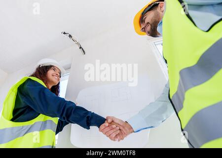 Young engineers doing handshake at construction site Stock Photo