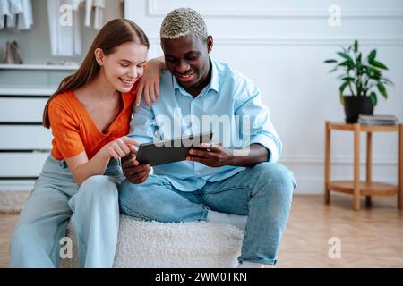 Happy young couple using tablet PC at home Stock Photo