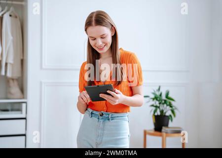 Happy young woman using tablet PC at home Stock Photo