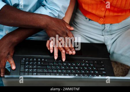 Hands of man and woman using laptop at home Stock Photo