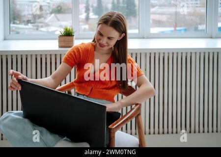 Smiling young freelancer using laptop at home Stock Photo