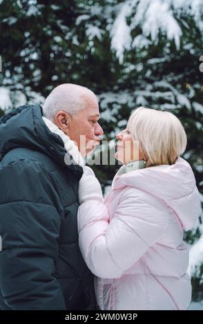 Man puckering lips to woman in warm clothes Stock Photo