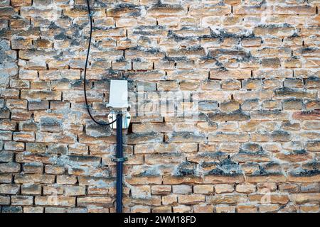 Electrical cable and wires installation on old brick wall as background Stock Photo