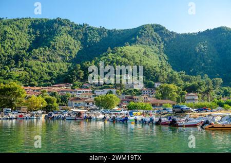 A small town harbor with boats on water in Thassos, Greece Stock Photo