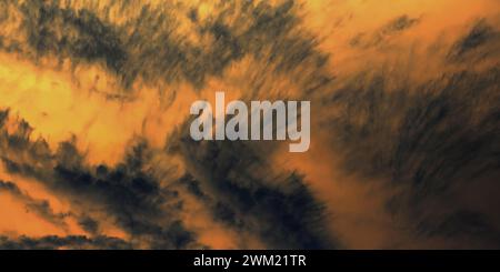 Golden sunset sky with dramatic dark clouds. Dark clouds contrasting a bright, golden sky. Stock Photo
