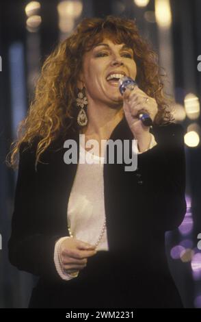 MME4764093 Sanremo Music Festival 1990. Italian pop singer and record producer Caterina Caselli sings “” Bisognerebbe non pensare che a te”” (coupled to the English version sung by Miriam Makeba: “” Give me a Reason”)/Festival di Sanremo 1990. Caterina Caselli canta “” Bisognerebbe non pensare che a te”” (abbinata alla versione inglese cantata da Miriam Makeba: “” Give me a Reason””) -; (add.info.: Sanremo Music Festival 1990. Italian pop singer and record producer Caterina Caselli sings “” Bisognerebbe non pensare che a te”” (coupled to the English version sung by Miriam Makeba: “” Give me a Stock Photo