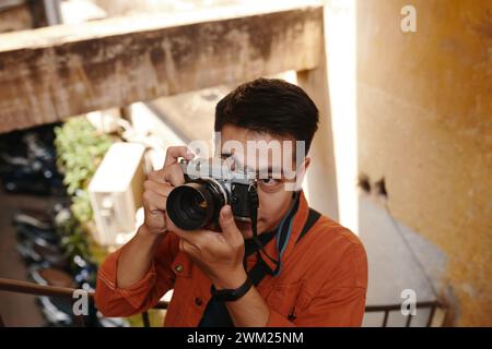 Vietnamese photographer taking pictures on abandoned building Stock Photo