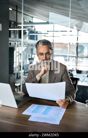Busy mature professional business man manager checking documents at work. Stock Photo