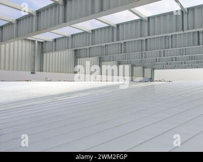 White SIN beams structure of a modern warehouse under construction. Metal frame painted white, constructing a large warehouse building. Stock Photo