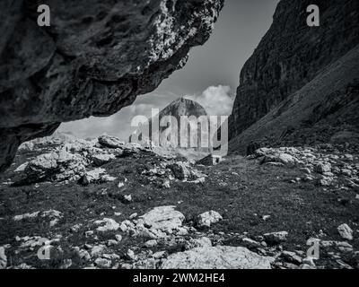 Majestic peak hidden between two mountains in black and white Stock Photo