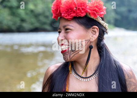 Smiling Beautiful woman from Embera tribe from a village in Chagres national park with traditional tattoos on her face and flowers in her hair, Panama Stock Photo