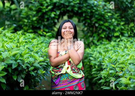 Beautiful woman from Embera tribe smiling and hiding her mouth with her hands, Chagres national park, Panama Stock Photo