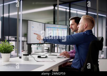 Accountants Looking At Invoice Spreadsheet On Computer Monitor Stock Photo