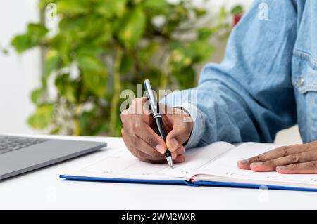 Close up of man hand writing in an agenda at home or office Stock Photo