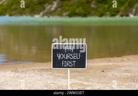 Pay yourself first symbol. Concept words Pay yourself first on beautiful black chalk blackboard. Beautiful mountain lake background. Business and pay Stock Photo