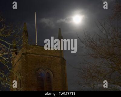 Sheerness, Kent, UK. 23rd Feb, 2024. UK Weather: the almost full Snow Moon above Holy Trinity Church in Sheerness, Kent this evening.  Credit: James Bell/Alamy Live News Stock Photo