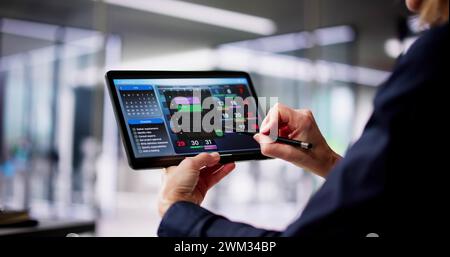 Executive Using Digital Calendar Agenda On Tablet Stock Photo