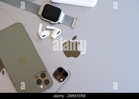 KYIV, UKRAINE - 4 MAY, 2023: Apple brand devices iphone, ipad and airpods with apple watch lies on macbook body close up Stock Photo