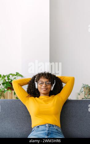 Vertical photo of young woman resting on sofa at home Stock Photo