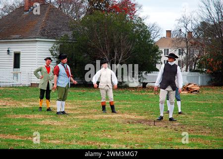 Costumed reenactors in Williamsburg participate in a colonial American pastime game Stock Photo