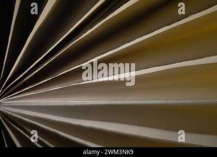 Abstract image of paper folded in a pleated pattern with yellow highlights and shadows Stock Photo