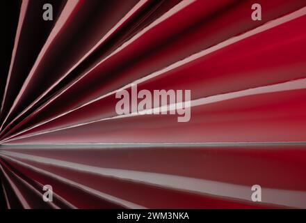 Abstract image of paper folded in a pleated pattern with red highlights and shadows Stock Photo