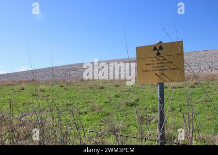 A “Uranium Mill Tailing Repository” and a “Radiation Warning” symbol on a sign along the perimeter fence at the Falls City disposal site near Karnes County, Texas, USA, on February 23, 2024. The Falls City disposal site contains 5.1 million cubic yards of contaminated material, with a total activity of 1,277 curries of radium- 226. The disposal site is located over the Eagle Ford Shale Geological Area, which is an active oil and gas producing region. Recently, the area has had 20 earthquakes of a magnitude 2.5 or or higher in a span of 30 days. (Photo by Carlos Kosienski/Sipa USA) Stock Photo