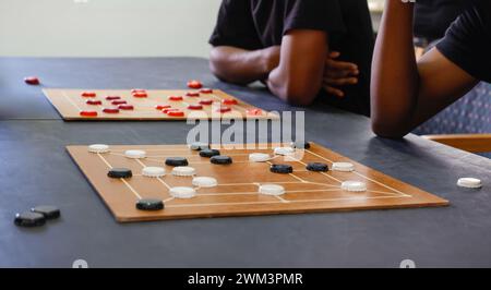 african american men with two boards playing, Nine men's morris strategy board game Stock Photo